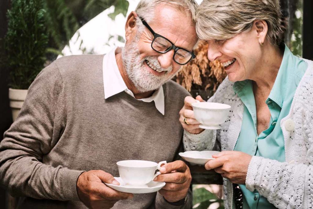 Independent Senior Living couple sipping tea and laughing