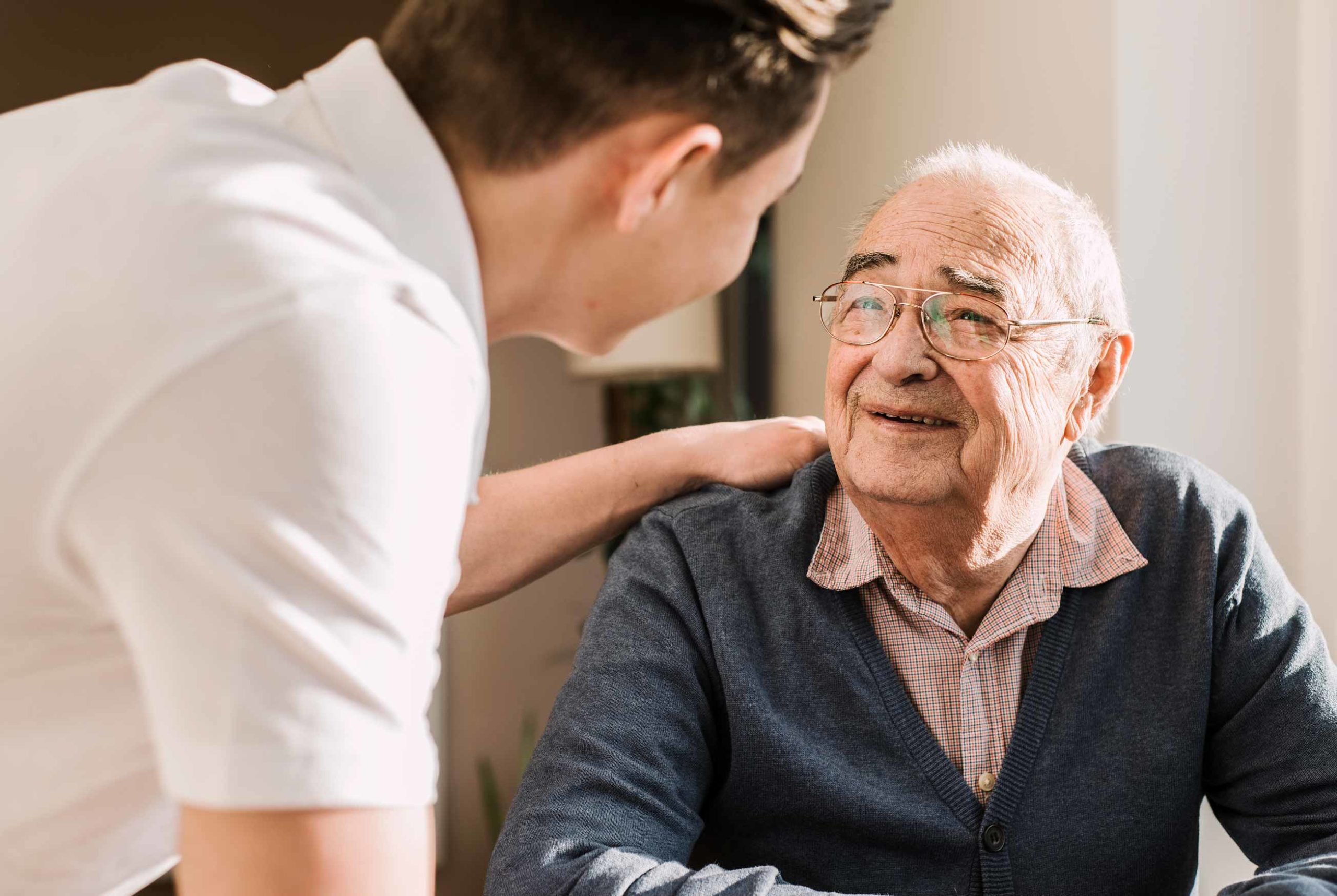Senior living caregiver connecting with memory care resident